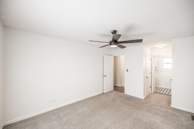 unfurnished bedroom featuring light colored carpet, ceiling fan, visible vents, and baseboards