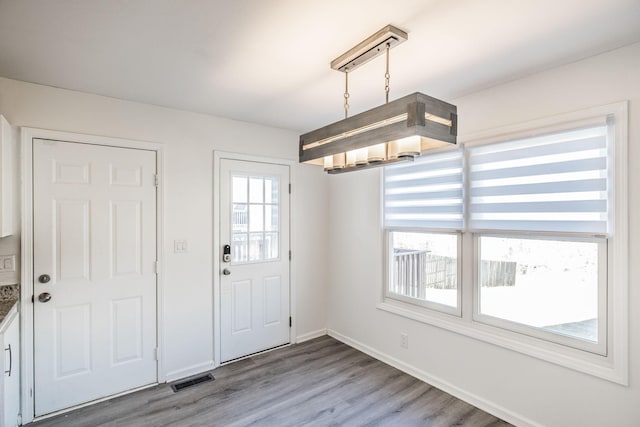 interior space with visible vents, baseboards, and wood finished floors