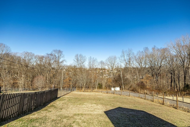 view of yard featuring a fenced backyard and a view of trees