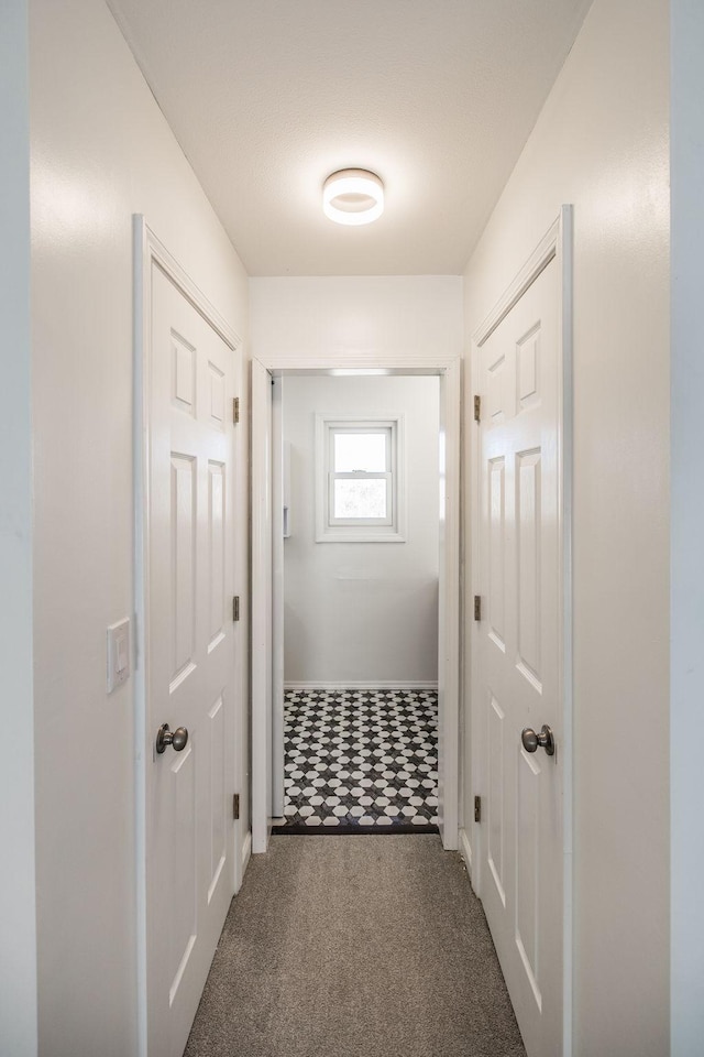 hall with carpet floors and baseboards