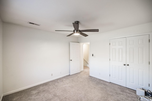 unfurnished bedroom with baseboards, a closet, visible vents, and light colored carpet