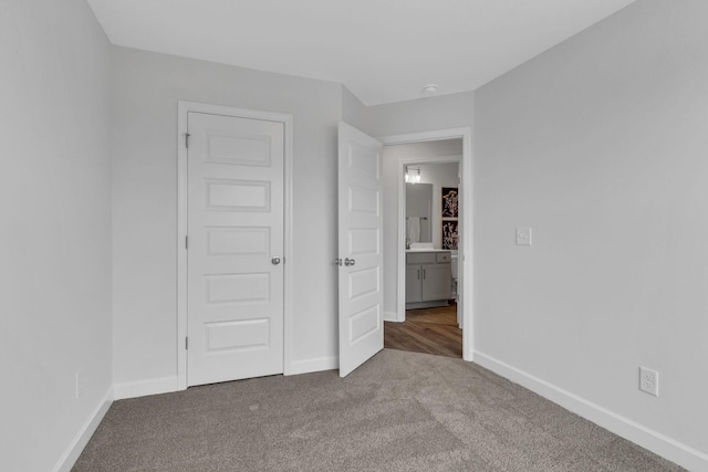 unfurnished bedroom featuring carpet floors and baseboards