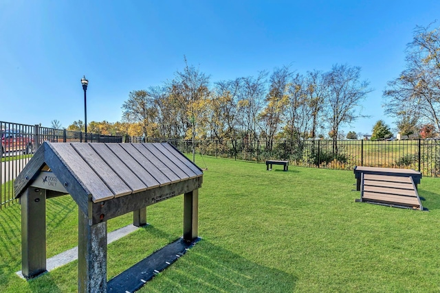 view of community with fence and a lawn