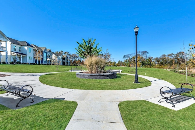 view of community with a patio, a lawn, and a residential view