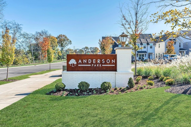 community / neighborhood sign featuring a residential view and a lawn