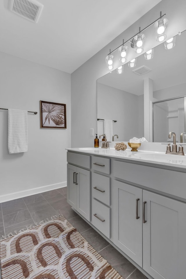 full bath featuring visible vents, a sink, a shower stall, and double vanity