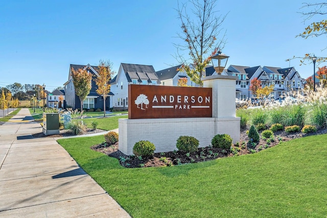 community / neighborhood sign with a residential view and a lawn