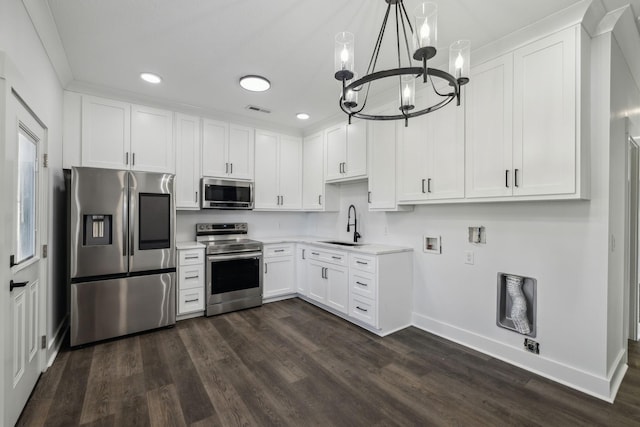 kitchen with stainless steel appliances, light countertops, white cabinetry, pendant lighting, and a sink