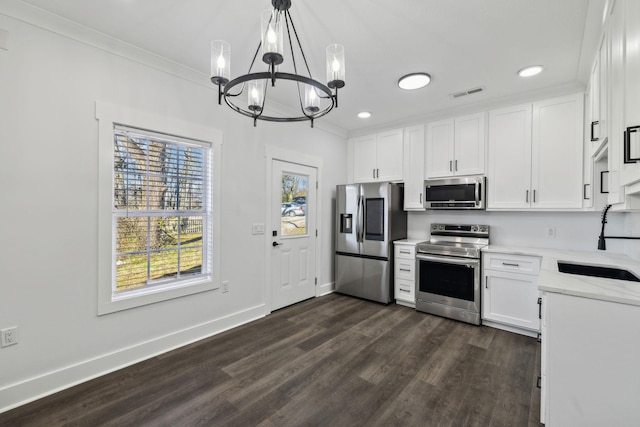 kitchen with visible vents, white cabinets, hanging light fixtures, stainless steel appliances, and a sink