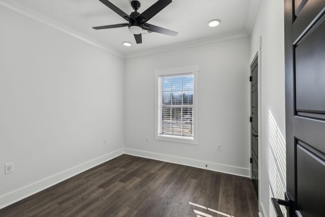 empty room featuring crown molding, dark wood finished floors, baseboards, and ceiling fan