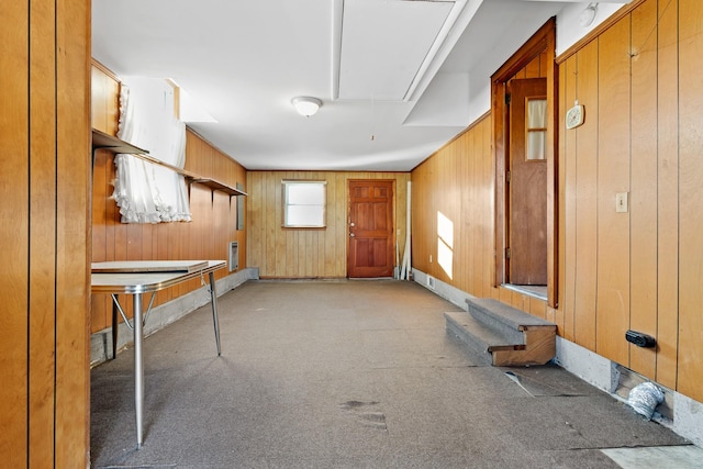 interior space with attic access, wooden walls, and light colored carpet