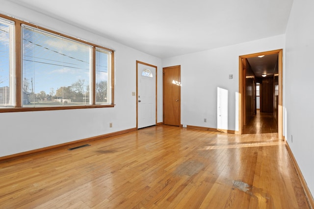 interior space featuring baseboards, visible vents, and light wood-style floors