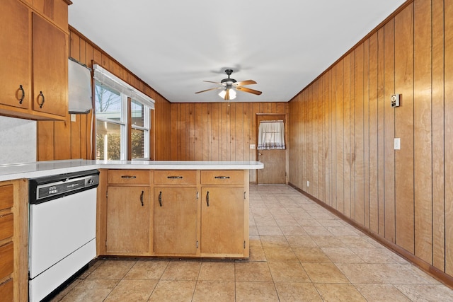 kitchen with light tile patterned floors, dishwasher, ceiling fan, brown cabinets, and light countertops