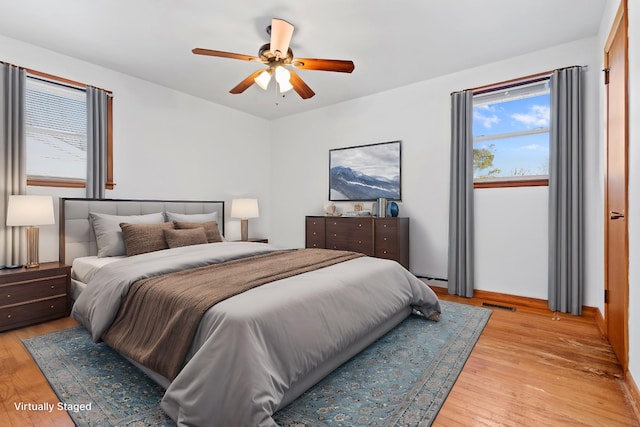 bedroom with light wood-style floors, visible vents, and a ceiling fan