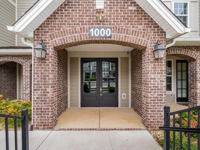 property entrance featuring french doors and brick siding