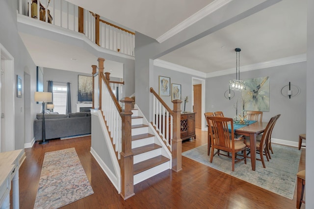 dining area with a notable chandelier, baseboards, stairs, ornamental molding, and dark wood-style floors