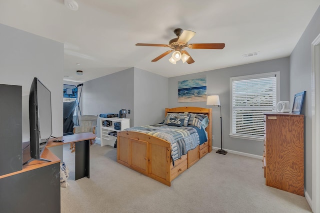 bedroom with light carpet, ceiling fan, visible vents, and baseboards
