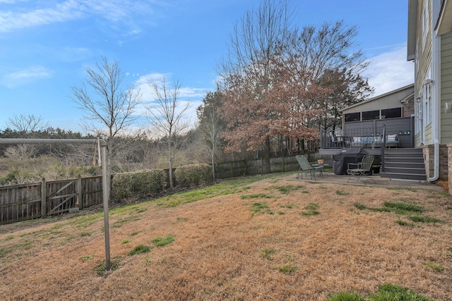 view of yard with a fenced backyard, a deck, and a patio