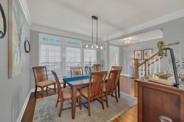dining room featuring baseboards, crown molding, stairway, and light wood finished floors
