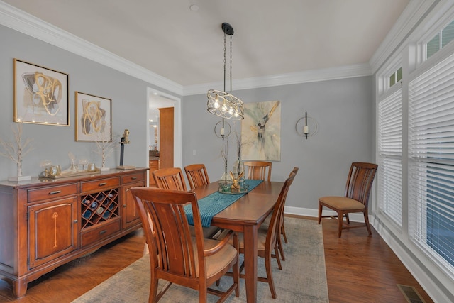 dining room with dark wood-type flooring, visible vents, crown molding, and baseboards