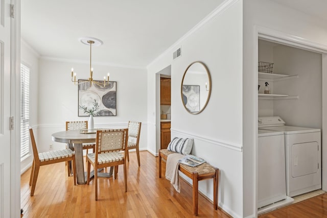 107 Sylvan Glen Ct, Nashville, TN 37209 - dining space with washing machine and clothes dryer, visible vents, light wood-style floors, ornamental molding, and a chandelier
