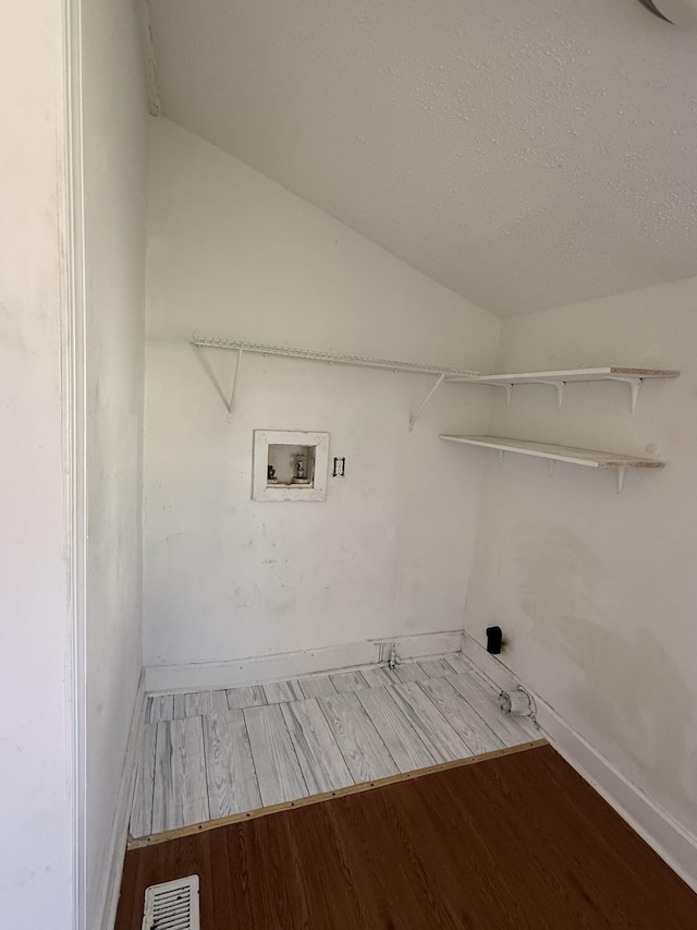 laundry area featuring hookup for a washing machine, wood finished floors, visible vents, baseboards, and laundry area