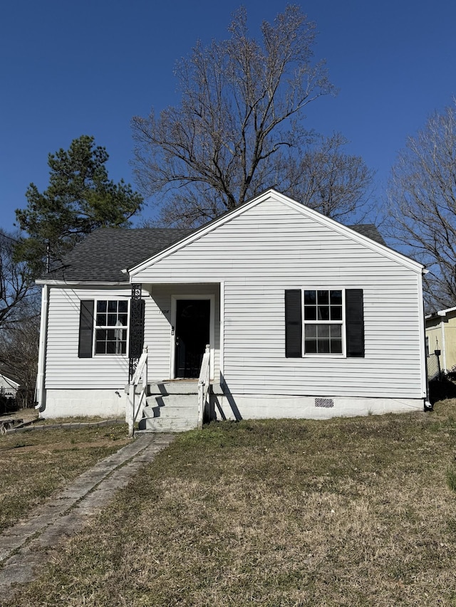 view of front of house with a shingled roof, a front lawn, and crawl space