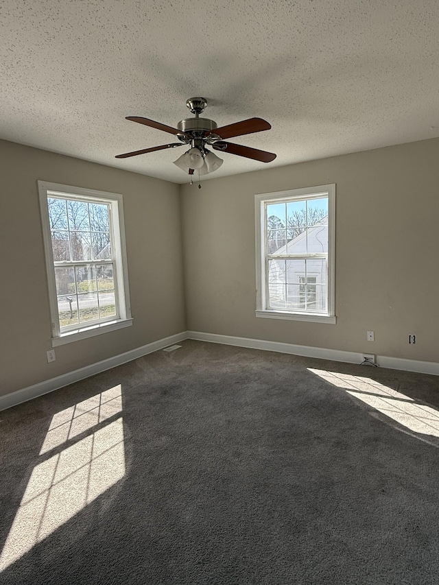 unfurnished room featuring dark carpet, a textured ceiling, and baseboards