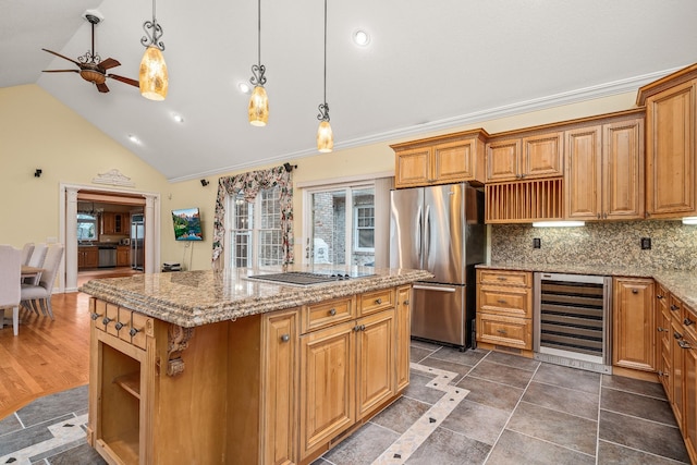kitchen featuring plenty of natural light, beverage cooler, black electric cooktop, and freestanding refrigerator
