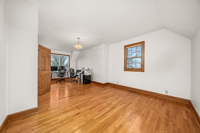 home office with vaulted ceiling, an inviting chandelier, baseboards, and light wood-style floors