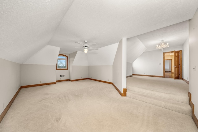 additional living space featuring baseboards, vaulted ceiling, a textured ceiling, carpet floors, and ceiling fan with notable chandelier