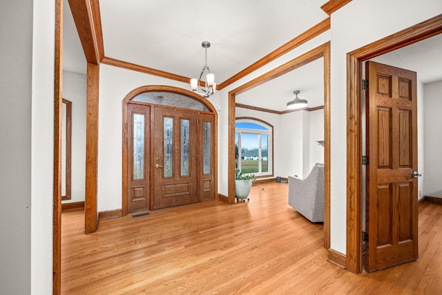 entryway with light wood-type flooring, a notable chandelier, and baseboards