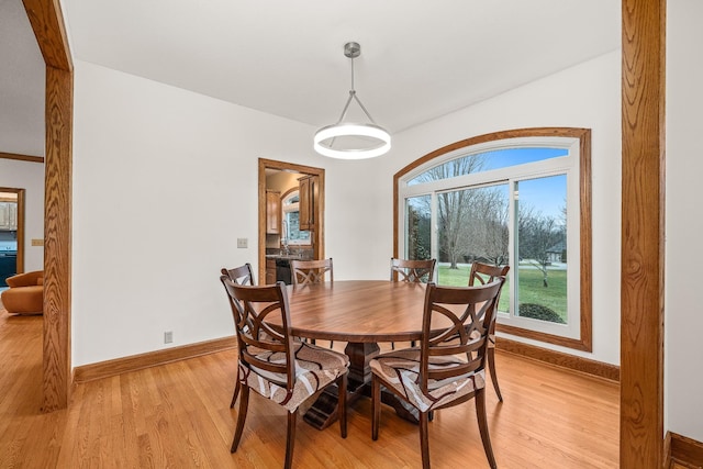 dining space featuring light wood-type flooring and baseboards