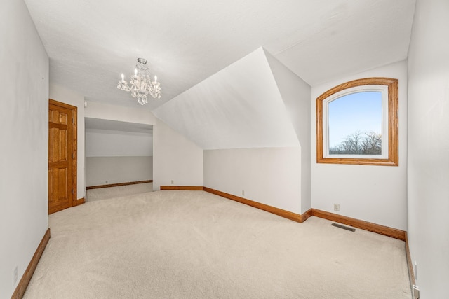 additional living space featuring carpet, lofted ceiling, visible vents, a chandelier, and baseboards