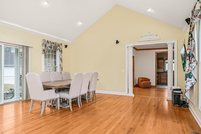 dining space featuring ornate columns, light wood-style flooring, baseboards, and crown molding