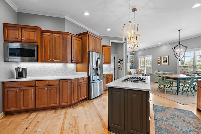 kitchen with a chandelier, stainless steel appliances, light wood-style floors, light countertops, and brown cabinetry