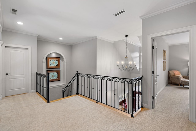 hall with an upstairs landing, visible vents, a notable chandelier, and carpet flooring