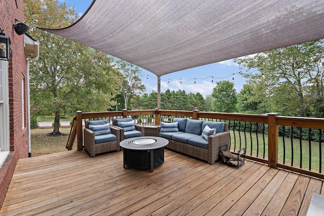 wooden terrace with an outdoor living space with a fire pit