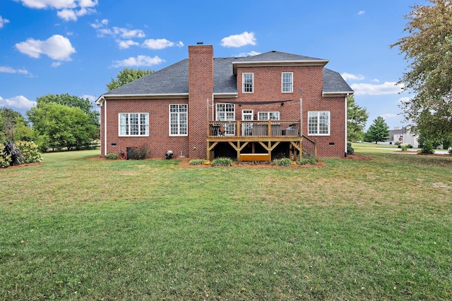 rear view of house with brick siding, a chimney, a lawn, crawl space, and a wooden deck