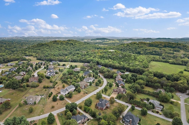 drone / aerial view featuring a residential view and a wooded view