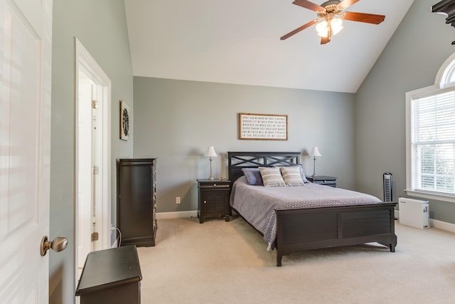 bedroom featuring light carpet, high vaulted ceiling, baseboards, and a ceiling fan