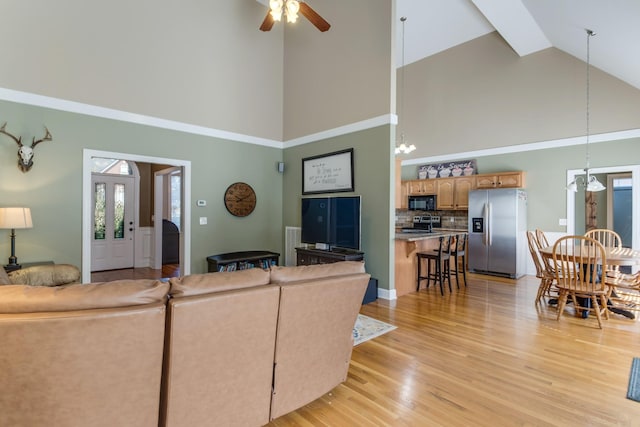 living area with ceiling fan, lofted ceiling, and light wood-style flooring