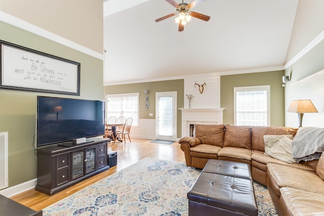 living area with light wood-style floors, crown molding, a fireplace, and visible vents