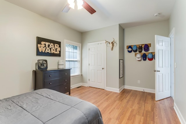 bedroom with baseboards, a ceiling fan, and light wood-style floors