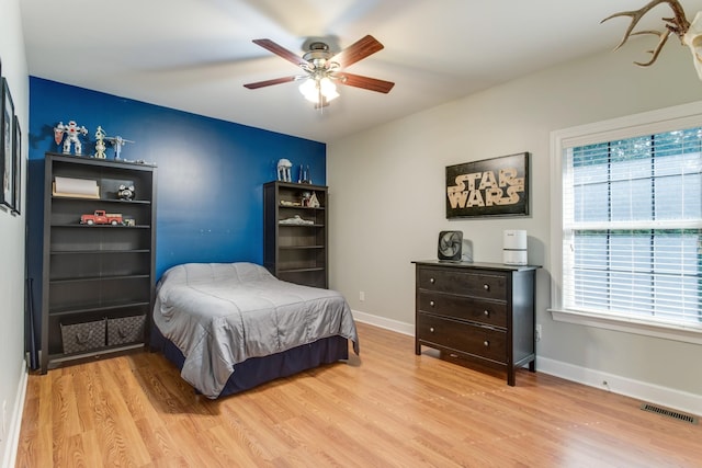 bedroom with baseboards, visible vents, and light wood-style floors