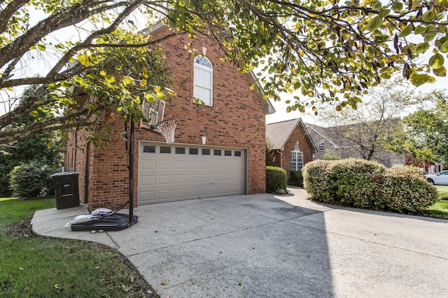 view of side of property with a garage, concrete driveway, and brick siding