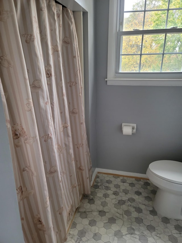 bathroom with toilet and baseboards