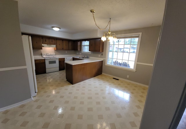 kitchen featuring white appliances, visible vents, a peninsula, an inviting chandelier, and light countertops