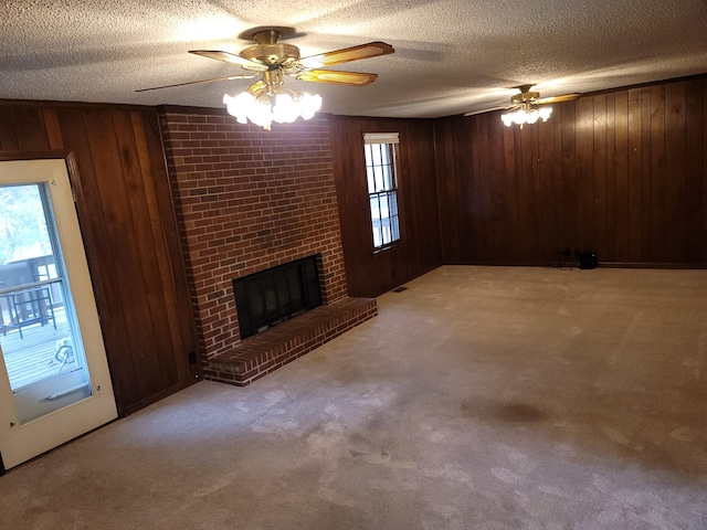 unfurnished living room featuring carpet floors, a healthy amount of sunlight, a fireplace, and a textured ceiling