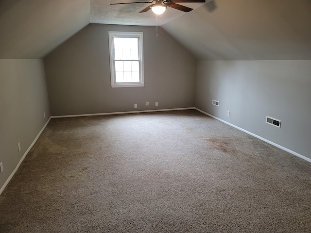 additional living space with vaulted ceiling, carpet floors, visible vents, and baseboards